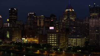 AX108_171 - 4K stock footage aerial video flying by skyscrapers and tilt down on Byham Theater, Downtown Pittsburgh, night