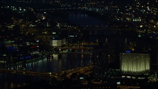 AX108_200E - 4K aerial stock footage of small bridges spanning the Allegheny River, Downtown Pittsburgh, Pennsylvania, night