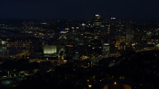 AX108_202E - 4K aerial stock footage of skyscrapers seen from Monongahela River, Downtown Pittsburgh, Pennsylvania, night