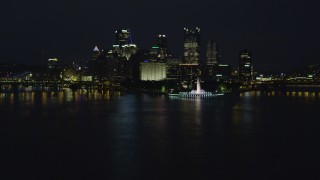 AX108_218 - 4K aerial stock footage of a low approach toward Point State Park, Downtown Pittsburgh, night