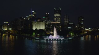 AX108_219 - 4K aerial stock footage flying over Point State Park toward skyscrapers, Downtown Pittsburgh, night