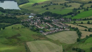 AX109_003 - 5.5K aerial stock footage of rural homes surrounded by green, Banton, Scotland