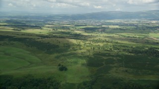 AX109_006E - 5.5K aerial stock footage approach farms in a green rural landscape, Stirling, Scotland