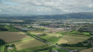 AX109_013 - 5.5K aerial stock footage video of flying over farms toward rural homes, Stirling, Scotland