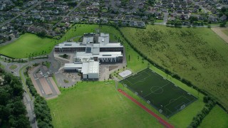 AX109_055 - 5.5K stock footage aerial video of orbiting Wallace High School and soccer field, Stirling, Scotland