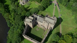 AX109_072 - 5.5K aerial stock footage of tilting to a bird's eye view of historic Doune Castle and its grounds, Scotland