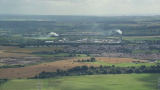 AX109_107E - 5.5K aerial stock footage of factory with smoke stacks in a small town of Cowie, Scotland