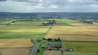 AX109_115 - 5.5K stock footage aerial video fly over roundabout on A905 highway by farm fields, Falkirk, Scotland