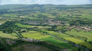 AX109_170 - 5.5K stock footage aerial video of Scottish farm fields and village homes in Bonnybridge, Scotland