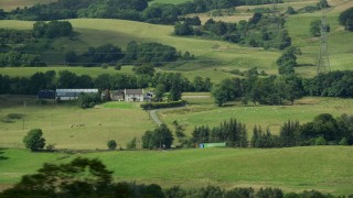 AX109_177 - 5.5K aerial stock footage of passing by a sheep farm in Cumbernauld, Scotland