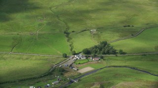 AX110_009E - 5.5K aerial stock footage tilt to bird's eye of a farm with green fields in Denny, Scotland