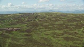 AX110_023E - 5.5K aerial stock footage fly over hills to approach Carleatheran, reveal farm fields, Scotland