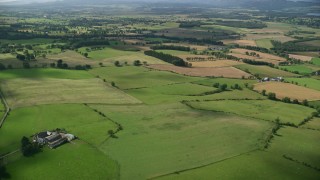 AX110_034 - 5.5K stock footage aerial video fly over farms and green fields, Kippen, Scotland