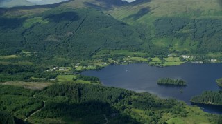 AX110_043E - 5.5K aerial stock footage of Loch Ard surrounded by forest by village of Blairhullichan, Scotland