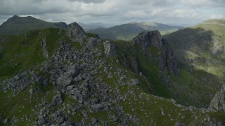 AX110_081E - 5.5K aerial stock footage of orbiting a jagged summit of The Cobbler, Scottish Highlands, Scotland