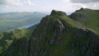 AX110_085 - 5.5K aerial stock footage of flying away from a mountain peak, The Cobbler, Scottish Highlands, Scotland