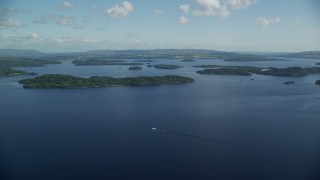 AX110_105E - 5.5K aerial stock footage pan across tree-covered islands in Loch Lomond, Scottish Highlands, Scotland