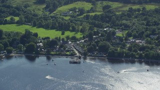 AX110_107 - 5.5K aerial stock footage orbiting a village on the shores of Loch Lomond, Luss, Scottish Highlands