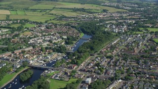 AX110_131E - 5.5K aerial stock footage fly over small bridges on River Leven in a small town, Alexandria, Scotland