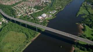 AX110_144 - 5.5K stock footage aerial video approach Erskine Bridge near neighborhoods in Glasgow, Scotland