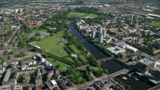 AX110_160 - 5.5K stock footage aerial video of monument and museum in Glasgow Green park by River Clyde, Scotland