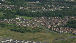 AX110_228 - 5.5K aerial stock footage of suburban homes and trees, Cumbernauld, Scotland