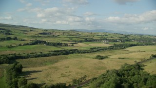AX111_001 - 5.5K aerial stock footage of green farm fields in a rural landscape, Bonnybridge, Scotland