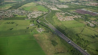 AX111_003 - 5.5K aerial stock footage approach M80 Highway through farmland and a village, Bonnybridge, Scotland