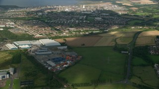 AX111_008 - 5.5K aerial stock footage of warehouses and suburban neighborhoods near gas power plant, Falkirk, Scotland