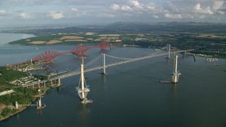 AX111_062 - 5.5K aerial stock footage of a view of the Forth Road Bridge and Forth Bridge on Firth of Forth, Scotland
