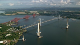 AX111_063 - 5.5K aerial stock footage of flying by Forth Road Bridge and Forth Bridge on Firth of Forth, Scotland