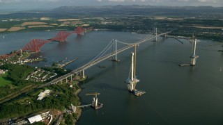 AX111_064 - 5.5K aerial stock footage video of the Forth Road Bridge and Forth Bridge on Firth of Forth, Scotland