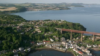 AX111_071 - 5.5K aerial stock footage of a commuter train approaching the Forth Bridge, North Queensferry,  Scotland