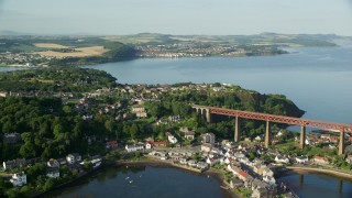 AX111_071E - Aerial stock footage of 5.5K aerial  video of a commuter train on Forth Bridge, North Queensferry, Scotland