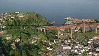 AX111_072 - Aerial stock footage of 5.5K aerial  video of a commuter train on Forth Bridge, North Queensferry, Scotland