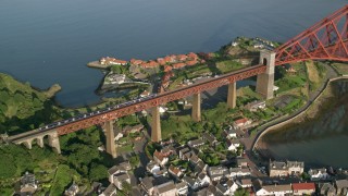 AX111_073 - 5.5K aerial stock footage of a commuter train on Forth Bridge in North Queensferry, Scotland