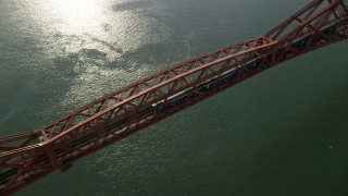 AX111_079 - 5.5K stock footage aerial video of a commuter train traveling on Forth Bridge over Firth of Forth, Scotland