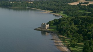 AX111_087 - 5.5K aerial stock footage of iconic Barnbougle Castle by Firth of Forth, Edinburgh, Scotland