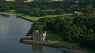 AX111_088 - 5.5K stock footage aerial video of historic Barnbougle Castle and Dalmeny House by Firth of Forth, Edinburgh, Scotland