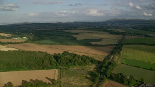 AX111_104 - 5.5K stock footage aerial video fly over rural landscape of farmland and trees, Edinburgh, Scotland