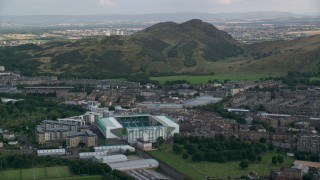 AX111_126 - 5.5K stock footage aerial video of Easter Road soccer stadium and Arthur's Seat mountain, Edinburgh, Scotland