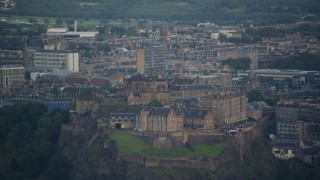 AX111_155E - 5.5K aerial stock footage of flying by Edinburgh Castle and cityscape, Scotland