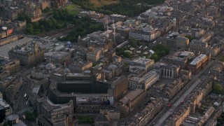 AX112_015 - 5.5K aerial stock footage of St Andrew Square and shopping mall, Edinburgh, Scotland at sunset