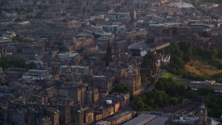 AX112_016E - 5.5K aerial stock footage of passing by The Hub and Edinburgh Castle, Scotland at sunset