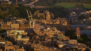 AX112_031E - 5.5K aerial stock footage video of Balmoral Hotel and Scott Monument in Edinburgh, Scotland at sunset