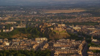 AX112_036E - 5.5K aerial stock footage of a view of Edinburgh Castle and cityscape, Scotland at sunset