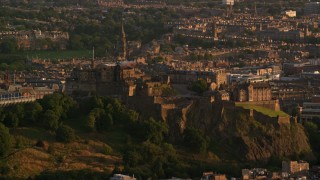 AX112_040 - 5.5K stock footage aerial video of Edinburgh Castle and cityscape, Scotland at sunset