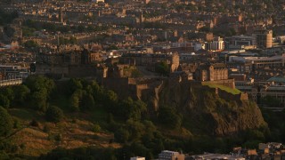 AX112_041 - 5.5K aerial stock footage of a view of Edinburgh Castle in Scotland at sunset