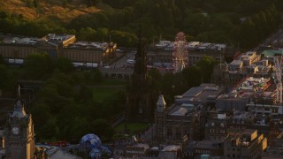 AX112_044E - 5.5K aerial stock footage of a view of Scott Monument and ferris wheel, Edinburgh, Scotland at sunset