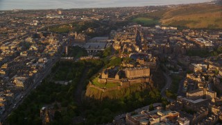 AX112_053E - 5.5K aerial stock footage of orbiting Edinburgh Castle and Cityscape, Scotland at sunset